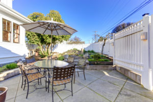 Backyard patio area with table, chairs and umbrella