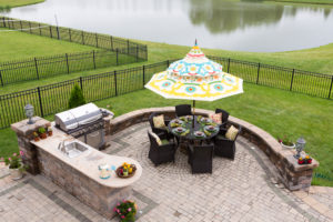 Outdoor living space on a brick patio overlooking a tranquil lake