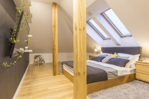 Master bedroom with wooden posts in an attic